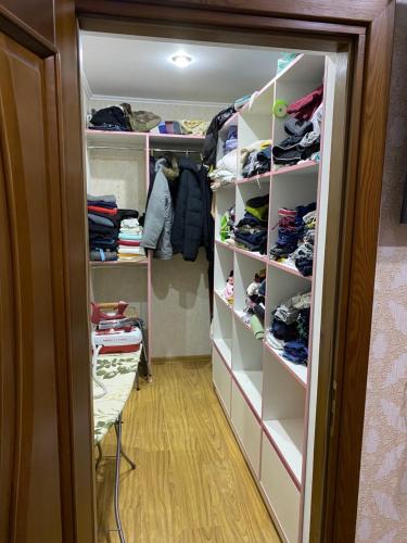 a walk in closet with white shelves at Apartments in Chişinău