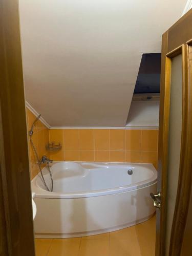 a white bath tub in a bathroom with orange tiles at Apartments in Chişinău