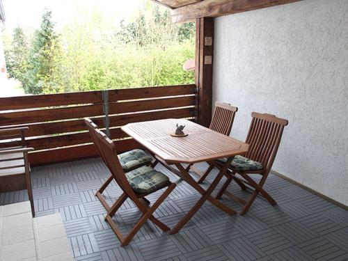 een houten tafel en 2 stoelen op een veranda bij Hirschhof Hildebrandt 