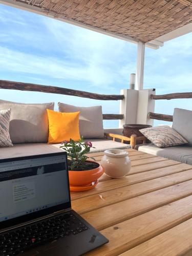 a laptop computer sitting on a wooden table on a deck at BigBlue Surf Experience Hostel in Taghazout