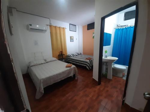 een slaapkamer met een bed, een wastafel en een spiegel bij Agradable Dpto en Garzota Norte Guayaquil in Guayaquil