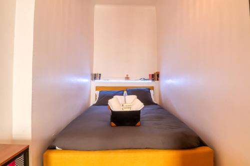Le Vintage, Appart,Hôtel particulier, centre Nîmes MaisonCarréeConciergerie في نيم: غرفة نوم صغيرة مع سرير في غرفة