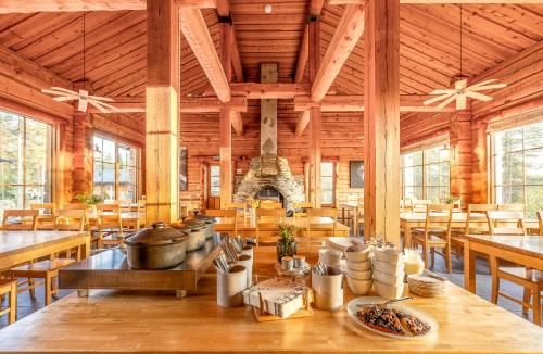 a large wooden building with tables and chairs at Basecamp Oulanka in Ruka