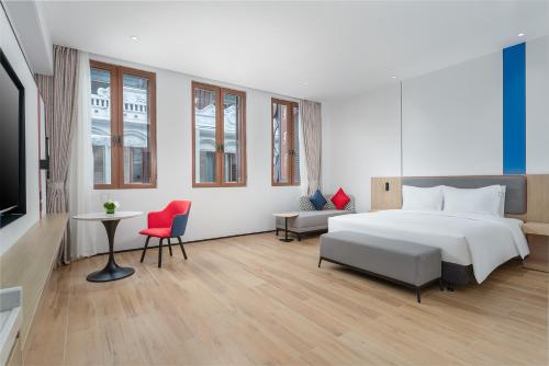 a hotel room with a bed and a table and chairs at Holiday Inn Express Wenchang by IHG in Wenchang