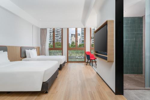 a hotel room with two beds and a flat screen tv at Holiday Inn Express Wenchang by IHG in Wenchang