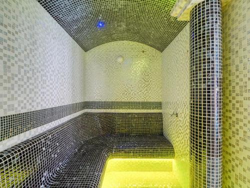 a bathroom with a shower with a yellow bench in it at Hotel Jan in Szczawnica