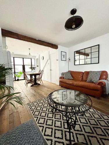 a living room with a couch and a glass table at Stunning 3 bedroom & 2 bathroom cottage with patio in Brighton & Hove