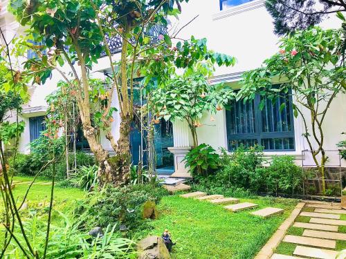 a house with a garden in front of it at Hotel Hoa Nắng in Bao Loc