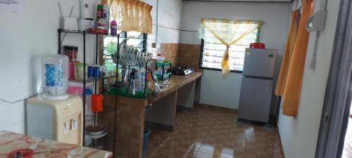 a kitchen with a counter and a refrigerator in a room at Hometostay Bokbak Kupang 