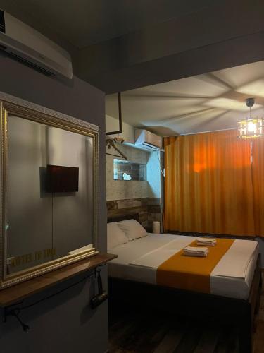 ein Schlafzimmer mit einem großen Bett und einem Spiegel in der Unterkunft Hotel In Time in Prizren