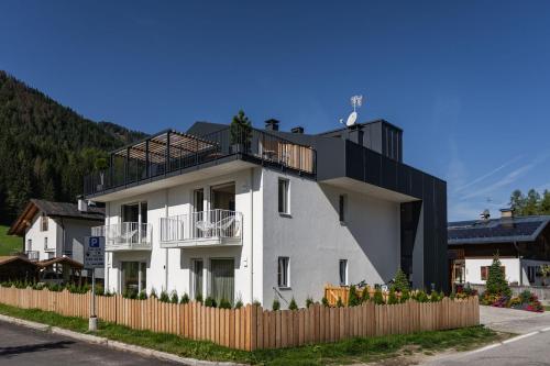 a white building with a fence in front of it at Ariane's Guesthouse in Sesto