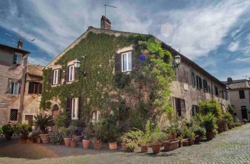 an ivycovered building with plants on the side of it at Felici’s apartment agli scavi di Ostia Antica in Ostia Antica