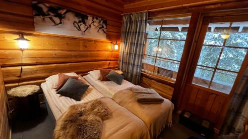 1 dormitorio con 2 camas en una cabaña de madera en Basecamp Oulanka, en Ruka