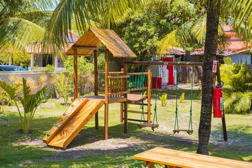 un parque infantil de madera con un columpio y un árbol en Privê Pontal de Maracaipe en Porto de Galinhas