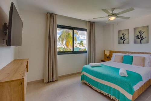 a bedroom with a bed and a tv and a window at Stylish and spacious penthouse with Bbq and picuzi in Punta Cana