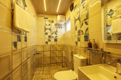 La salle de bains est pourvue de toilettes et d'un lavabo. dans l'établissement Green Wood Hill Cottage, à Ooty