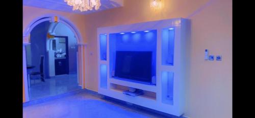sala de estar con TV de pantalla plana en la pared en Stunning 3-Bedrooms GuestHouse in Limbe Cameroon, en Limbe