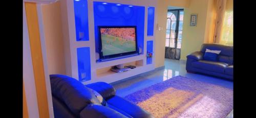 a living room with a couch and a flat screen tv at Stunning 3-Bedrooms GuestHouse in Limbe Cameroon in Limbe