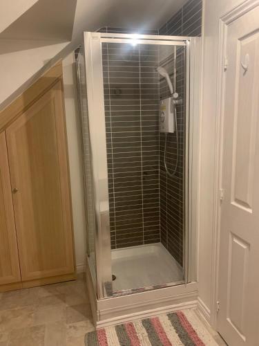 een douche in een badkamer met een glazen deur bij Comfy double Bedroom in Greater Manchester in Manchester