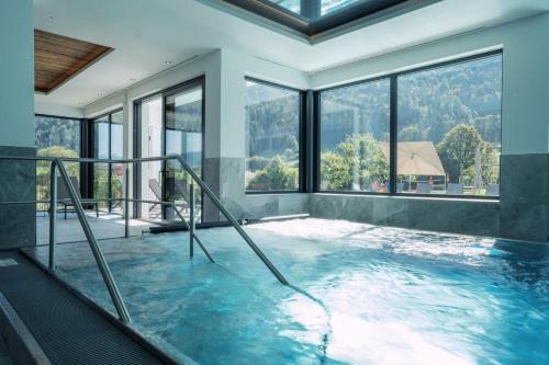 a large swimming pool in a house with windows at Feriengut Unterhochstätt in Schwendt