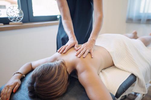 a woman getting a massage from a therapist at Feriengut Unterhochstätt in Schwendt