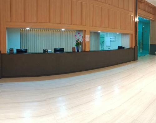 a lobby with a reception desk in a building at Mayflower Grande Suite Hotel in Phitsanulok