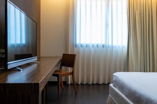 a hotel room with a desk with a television and a bed at ETH Rioja in Haro