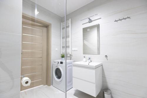 baño blanco con lavadora y lavamanos en Apartament 8B Wały Chrobrego Szczecin, en Szczecin