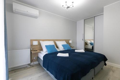 1 dormitorio con 1 cama grande con sábanas azules en Apartament 8B Wały Chrobrego Szczecin, en Szczecin