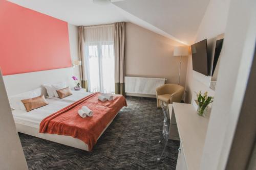a hotel room with a bed with a red wall at Caro Boutique Hotel in Oradea
