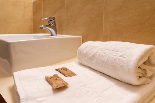 y baño con lavabo y toallas en la encimera. en Kyriad Direct ETH Rioja, en Haro