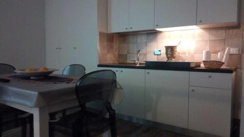 eine Küche mit einem Waschbecken und einem Tisch mit Stühlen in der Unterkunft Casavacanzefranca - 12 in Terrasini