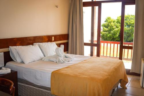 a bed in a room with a large window at Pasargada Hotel in Crato