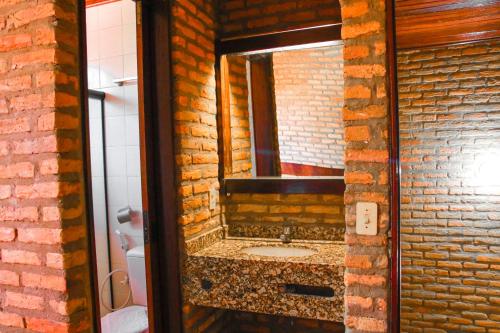 a bathroom with a sink in a brick wall at Pasargada Hotel in Crato