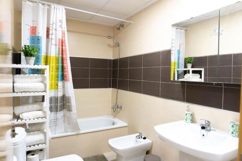 Estupendo apartamento en el grao في غانديا: حمام مع حوض ومرحاض وحوض استحمام