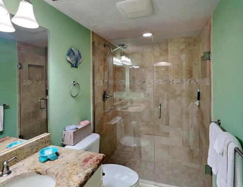 a bathroom with a shower and a toilet and a sink at Oceanside Retreat 804 in Ormond Beach
