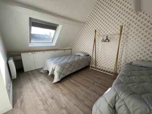 a bedroom with two beds and a window at Maison à 6min du Parc Disneyland Paris in Magny-le-Hongre