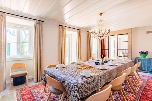 a dining room with a long table and chairs at Villa Azzurra Cascais 5BR in Cascais