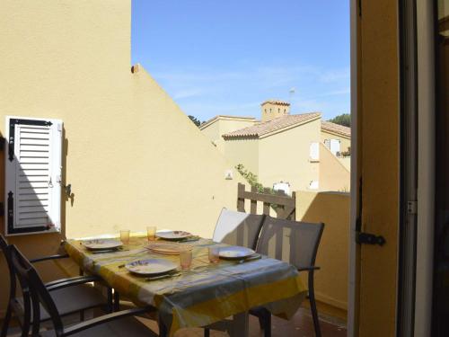 - une table avec des plaques sur le balcon dans l'établissement Appartement Climatisé à 450m Plage avec Terrasse et Parking Privé - 7 Couchages, Cap d'Agde - FR-1-249-44, au Cap d'Agde
