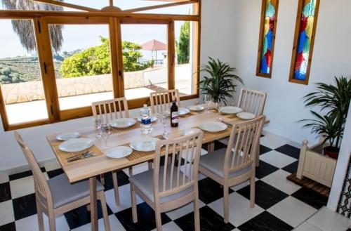 comedor con mesa, sillas y ventana en CASA EL GARDO, en Sayalonga