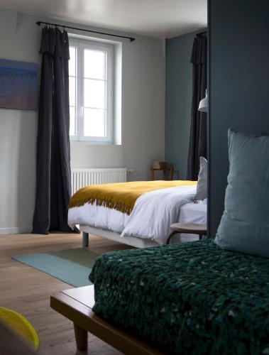 une chambre avec deux lits et une fenêtre dans l'établissement La Maison Plûme, à Villequier