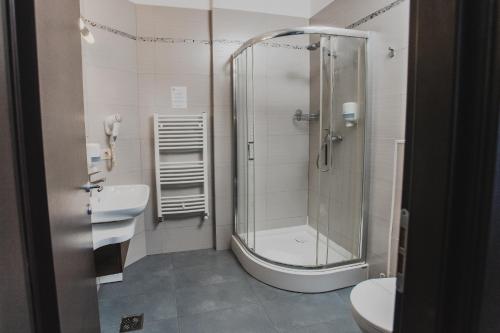 a bathroom with a shower and a toilet and a sink at Caro Boutique Hotel in Oradea