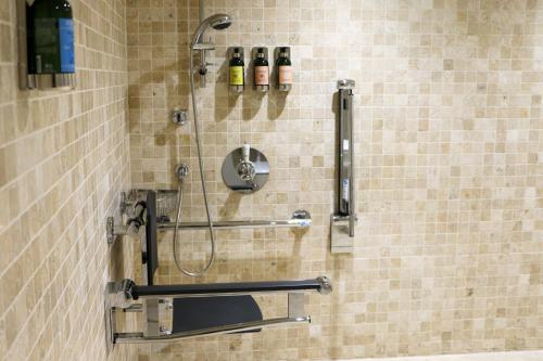 a shower in a bathroom with two bottles on the wall at South Sands Hotel in Salcombe