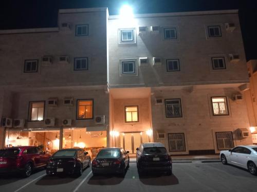 a group of cars parked in a parking lot in front of a building at سحاب in Yanbu