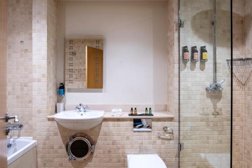 a bathroom with a toilet sink and a shower at South Sands Hotel in Salcombe