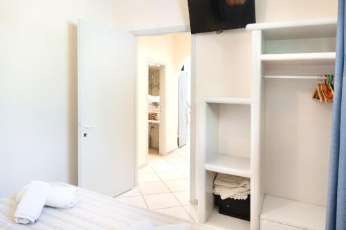 a bedroom with white walls and a bed and a hallway at Elysium in Glinádhon