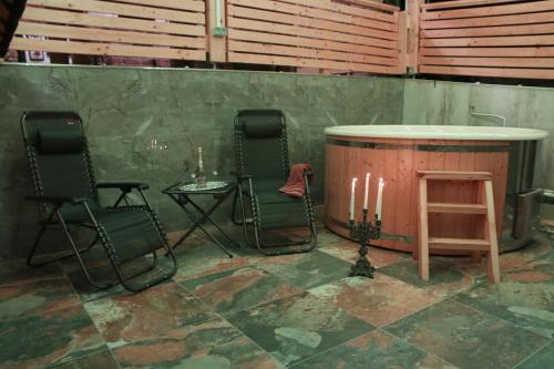 a room with two chairs and a tub with candles at Vila Tamaškut in Lendava
