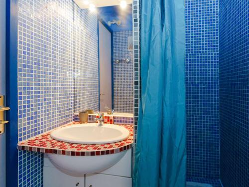 La salle de bains est pourvue d'un lavabo et d'une douche bleue. dans l'établissement Appartement T2 bord de mer 2 pers, animaux admis, parking public, location draps & serviettes - FR-1-409-25, à Narbonne-Plage