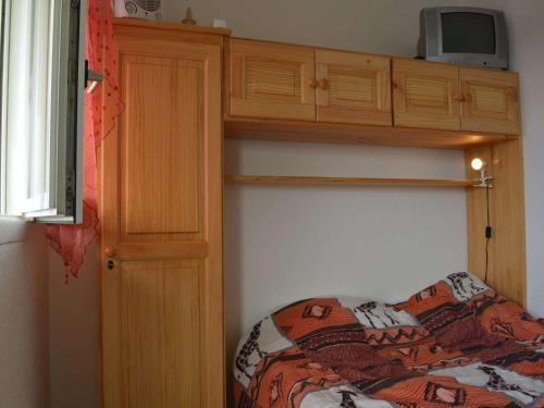 - une chambre avec des lits superposés et une télévision au-dessus dans l'établissement Appartement T2 bord de mer avec piscine, parking, Saint-Cyprien Plage - FR-1-225D-13, à Saint Cyprien Plage