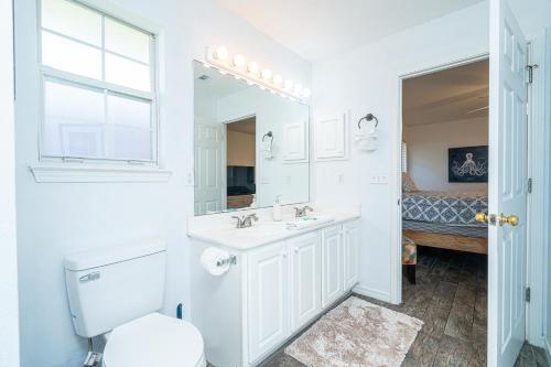 een badkamer met een wastafel, een toilet en een spiegel bij WINDSTARR DESTIN- Golf Cart Included, One level, Close to beach, Pet friendly in Destin